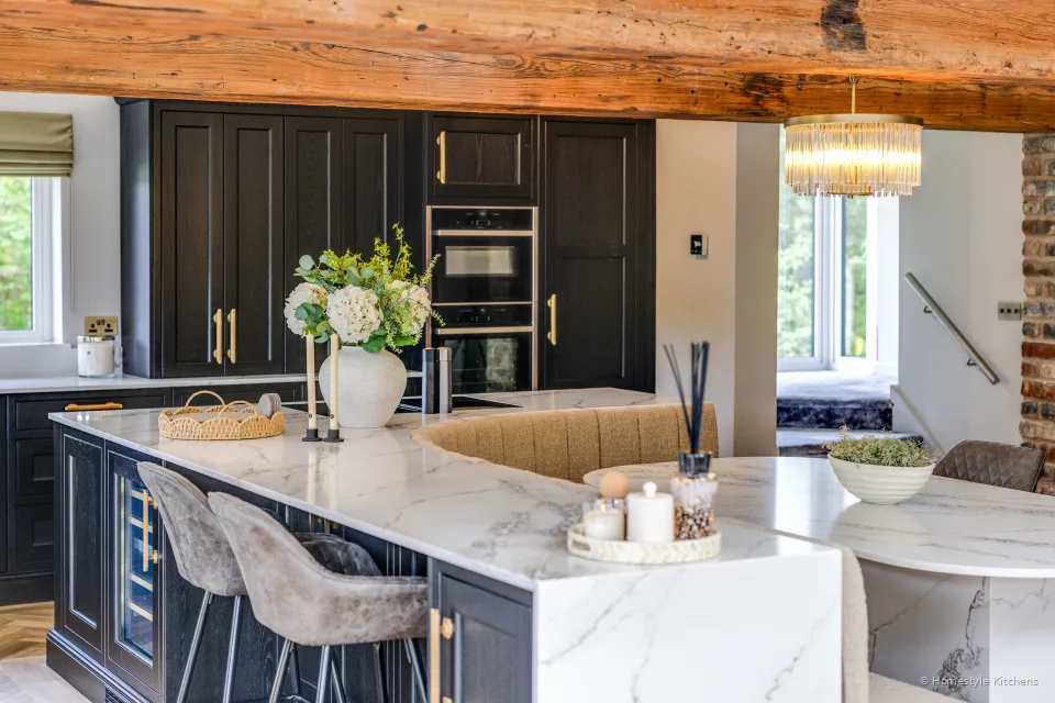 Charcoal Shaker kitchen with a white veined quartz island, brass handles and timber beams.