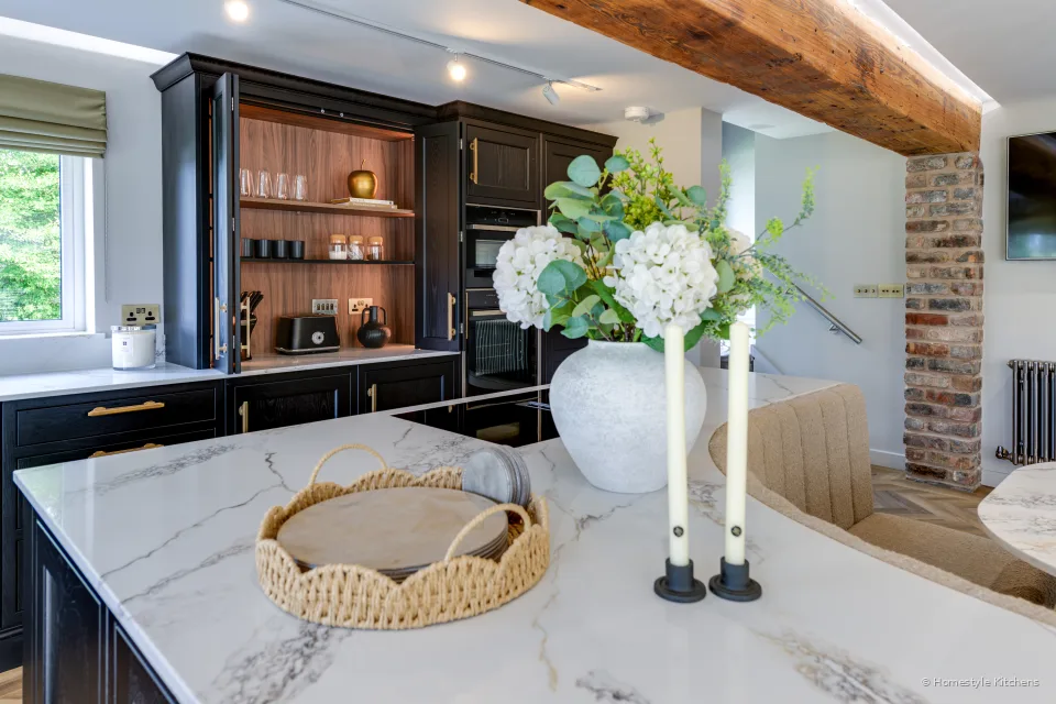 Bold-veined white quartz island, charcoal units and open glassware shelves.