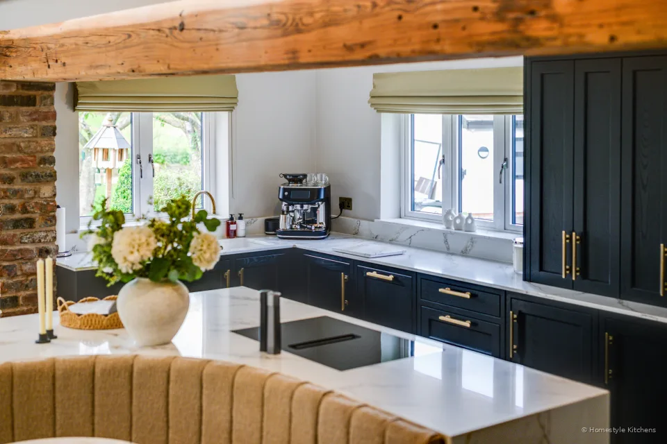 Across the island to charcoal cabinetry, black hob and coffee machine.