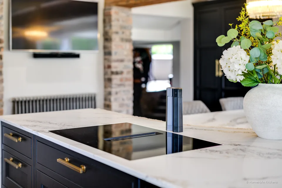Black Neff vented hob in white veined quartz on a charcoal Shaker island.