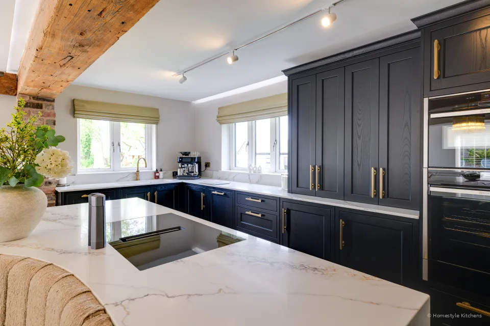 Charcoal Shaker cabinetry, white quartz island, black hob and oven bank.