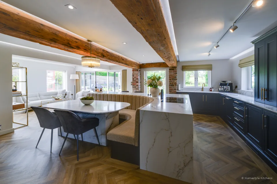 Across a white quartz island to charcoal cabinetry and open display shelving.