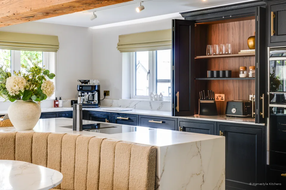 Island and charcoal appliance wall with espresso machine and open shelving.