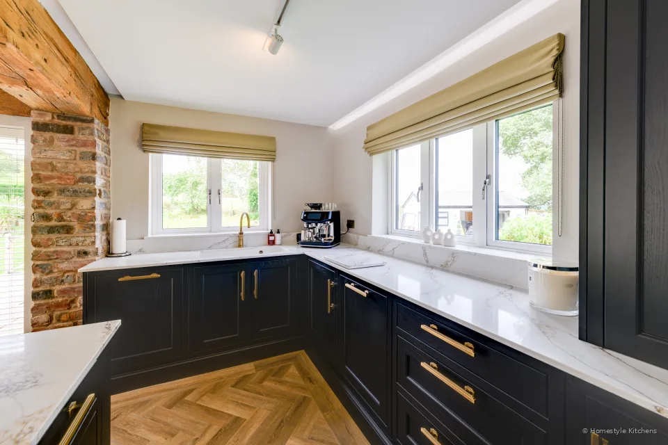 Charcoal Shaker corner under windows, brass tap and white sink on white quartz.