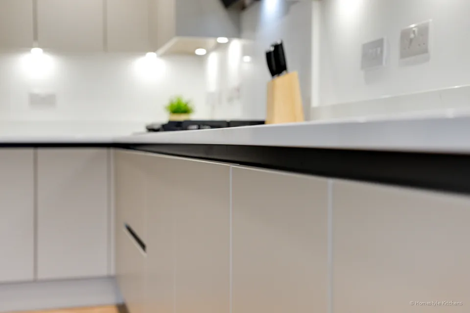 Worktop with coffee kit and knife block, pale grey cabinets.