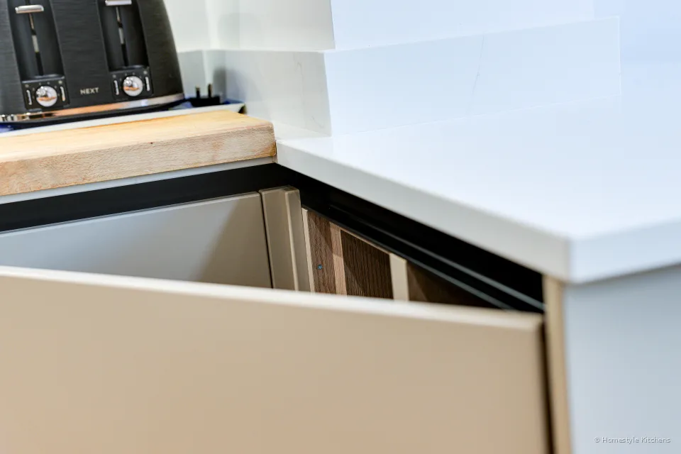 Open drawer under a pale worktop with fitted kitchen storage.