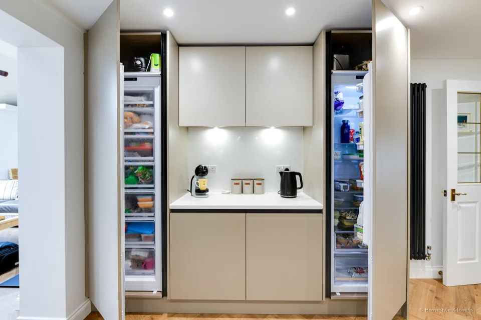 Open pocket doors on tall units showing integrated fridge and freezer.