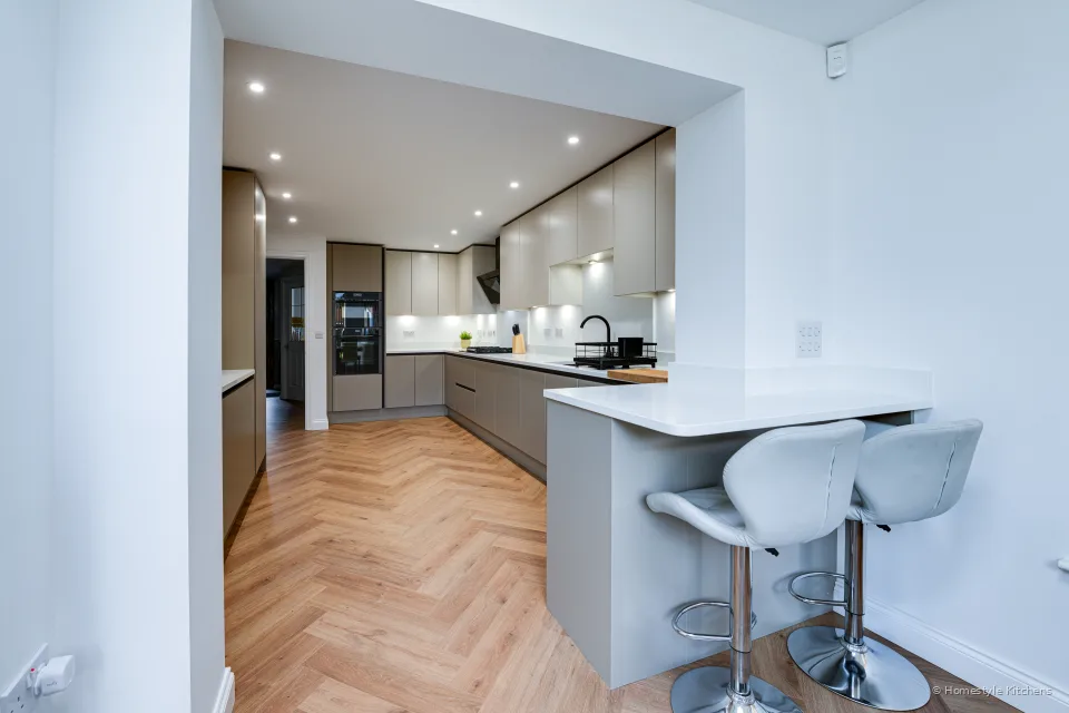 Looking toward the island and dining, pale grey cabinets and black tap.