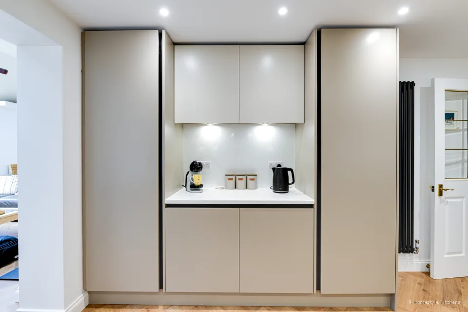 Tall bank of closed pale grey cabinetry with integrated appliances.
