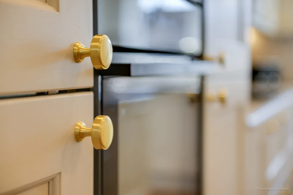 Brass round knobs on cream painted shaker drawer fronts.