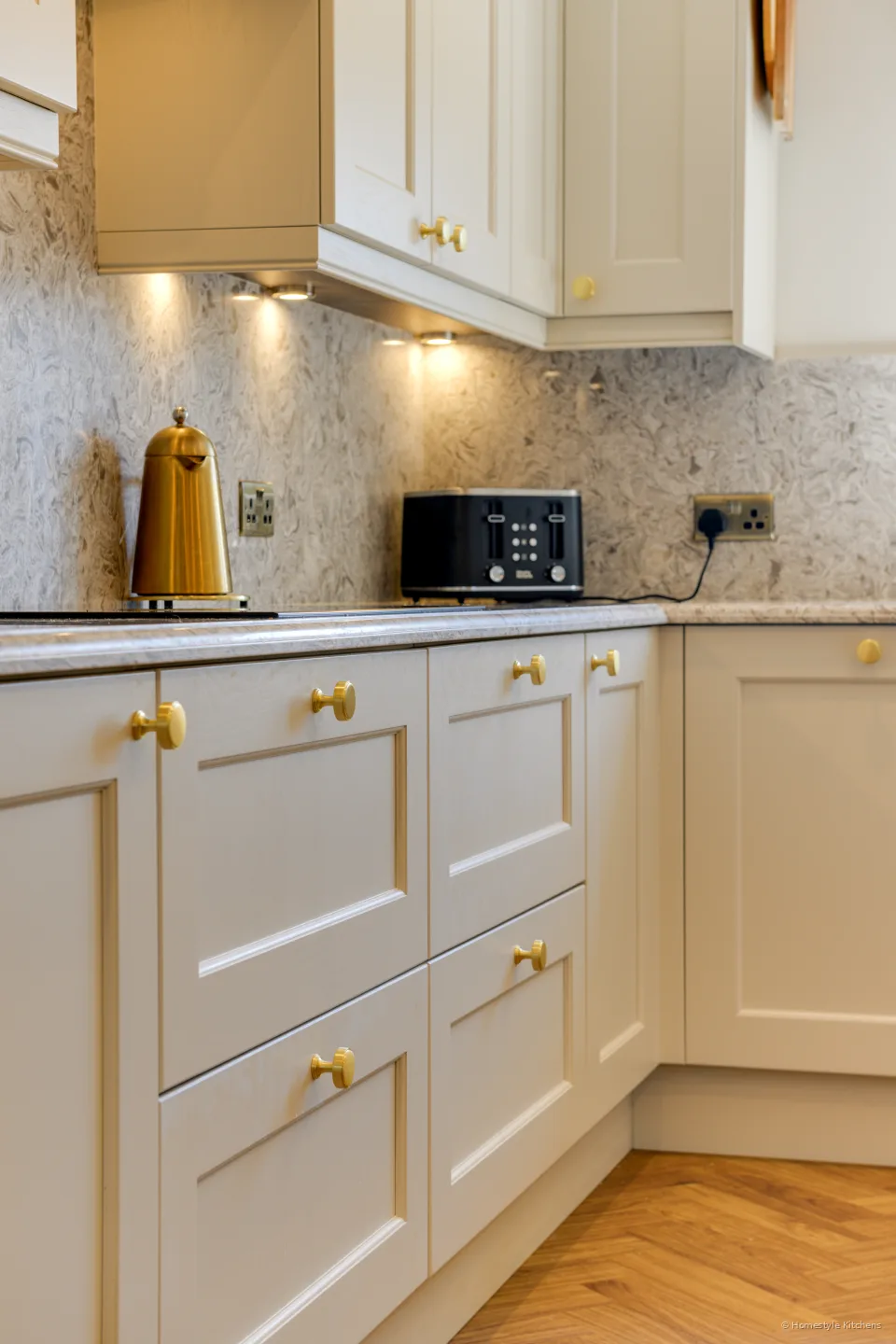 Cream painted cabinet meeting a marbled quartz splashback.