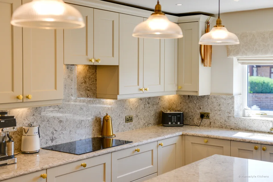 Hob run and quartz worktop corner, glass pendants above the island.