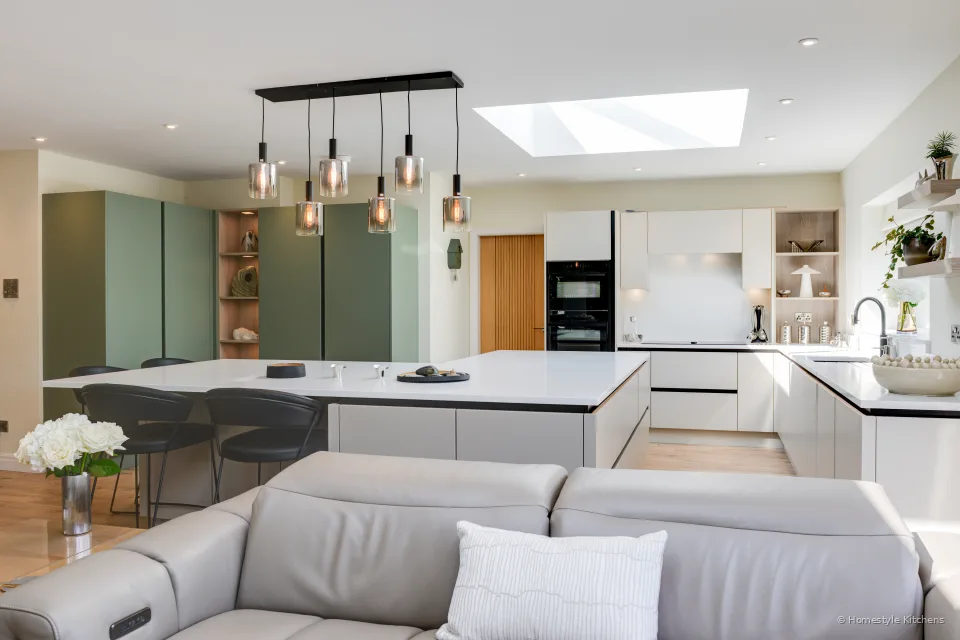 Looking across the sofa to the island and copper pendants.