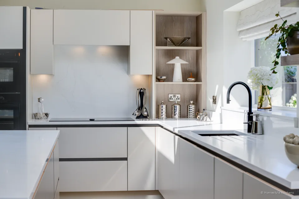 Worktop run with a black tap and oak shelf, mocha units.