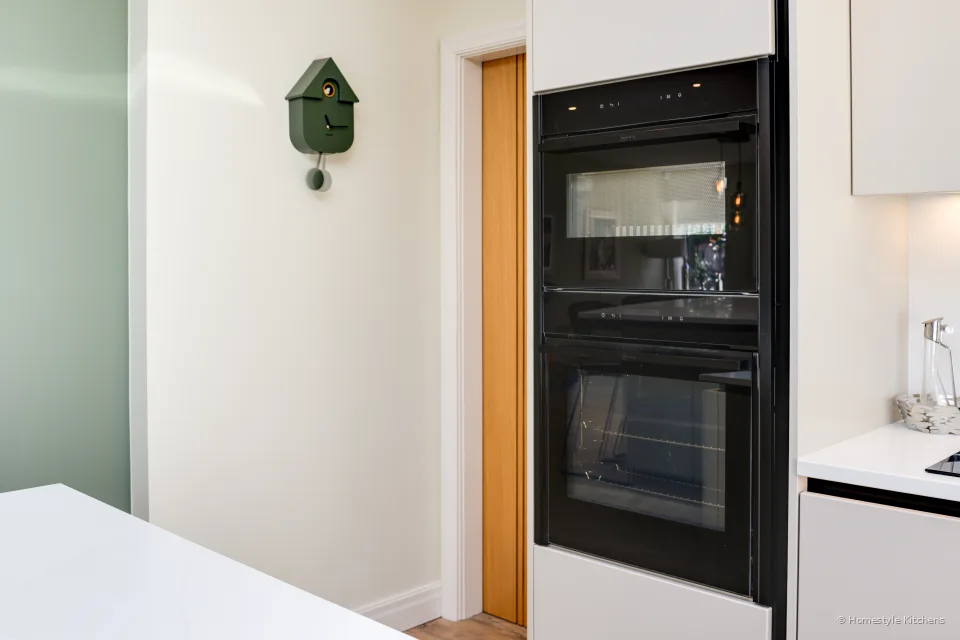 Corner of the black oven housing, sage wall and oak door.