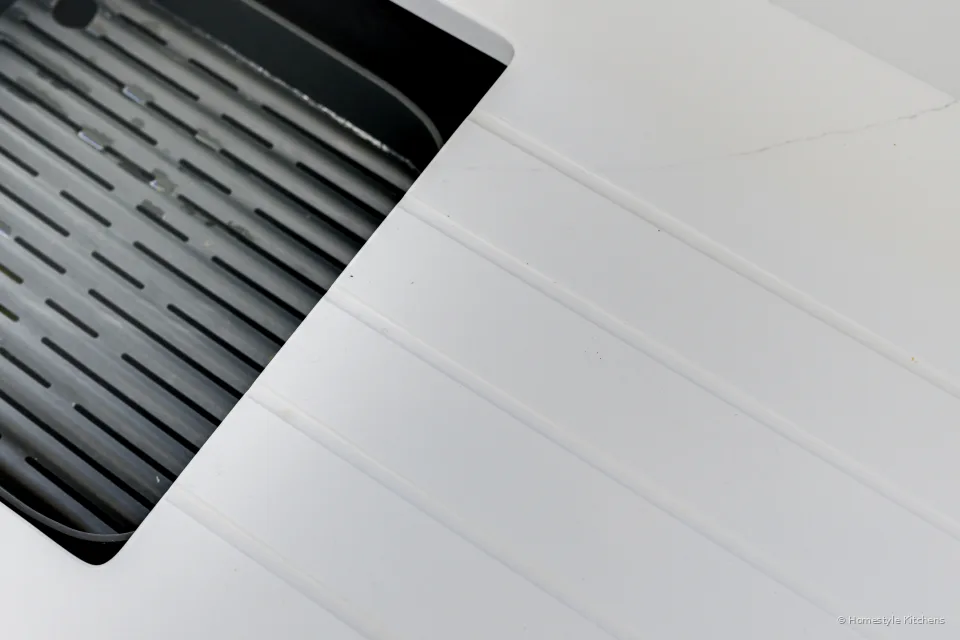 Black induction hob surface in white quartz.