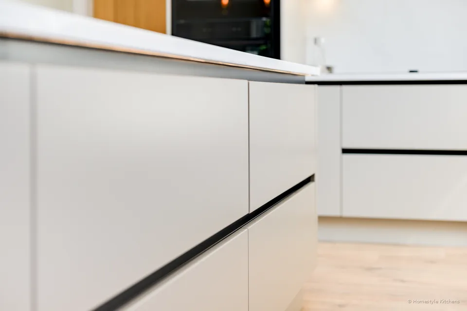 Handleless cream drawer line and quartz edge.