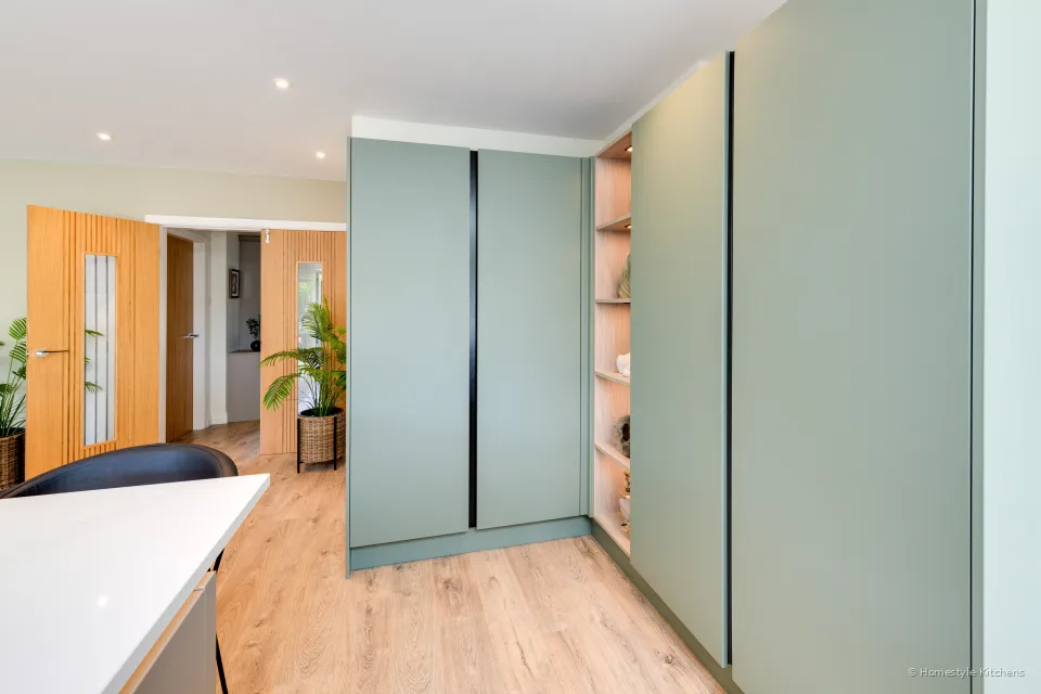 Reed green tall larder units beside an oak door.