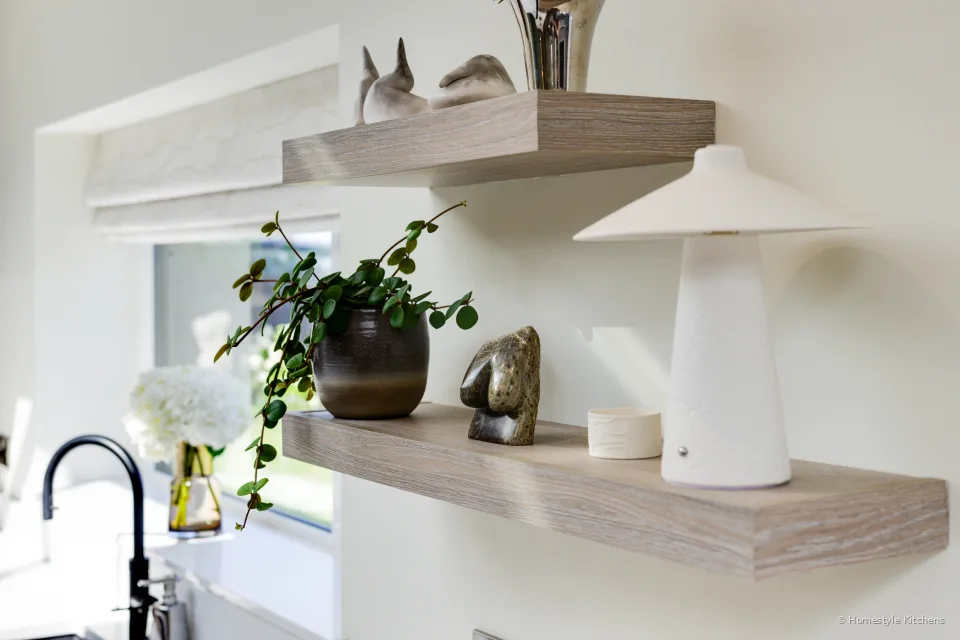 Oak shelves with plants over the worktop, black tap, canopy above.