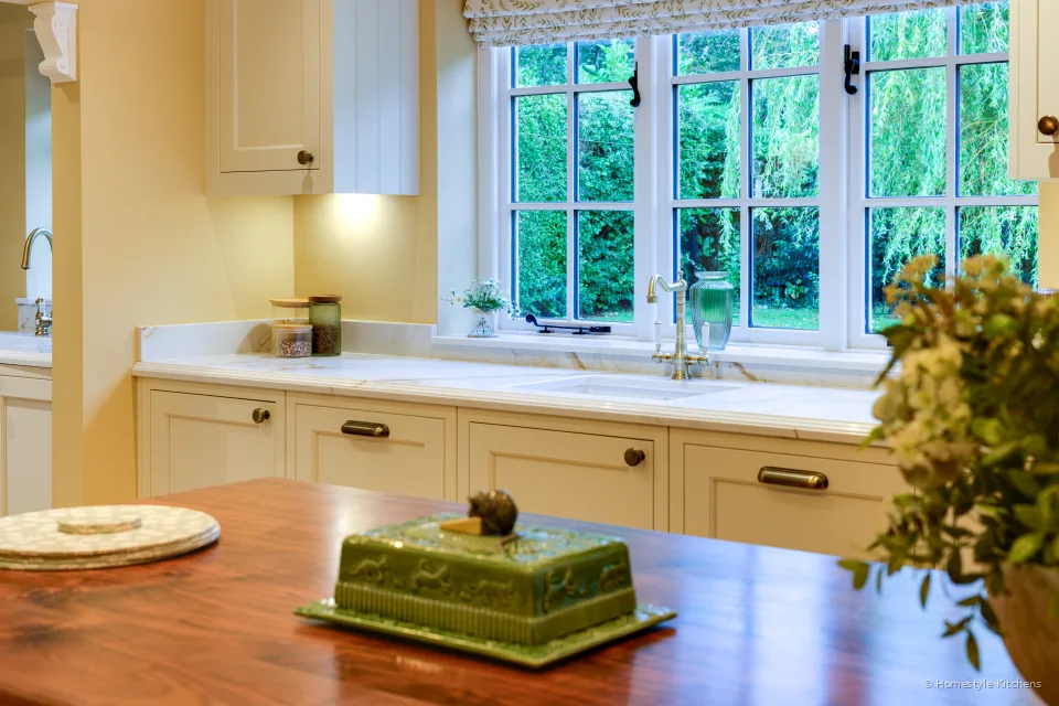 Calacatta Gold worktop and ceramic sink under a window, oak island top in the foreground.