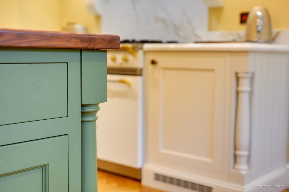Green painted island corner against a cream painted run with Calacatta Gold worktop.