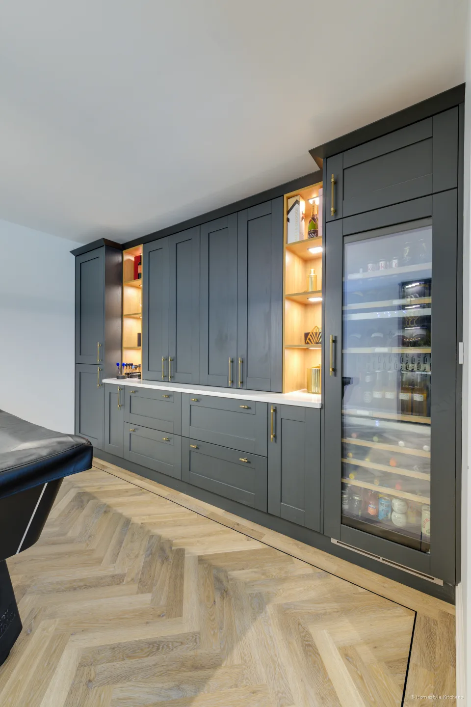 Tall glazed drinks fridge in a dark shaker bar run.