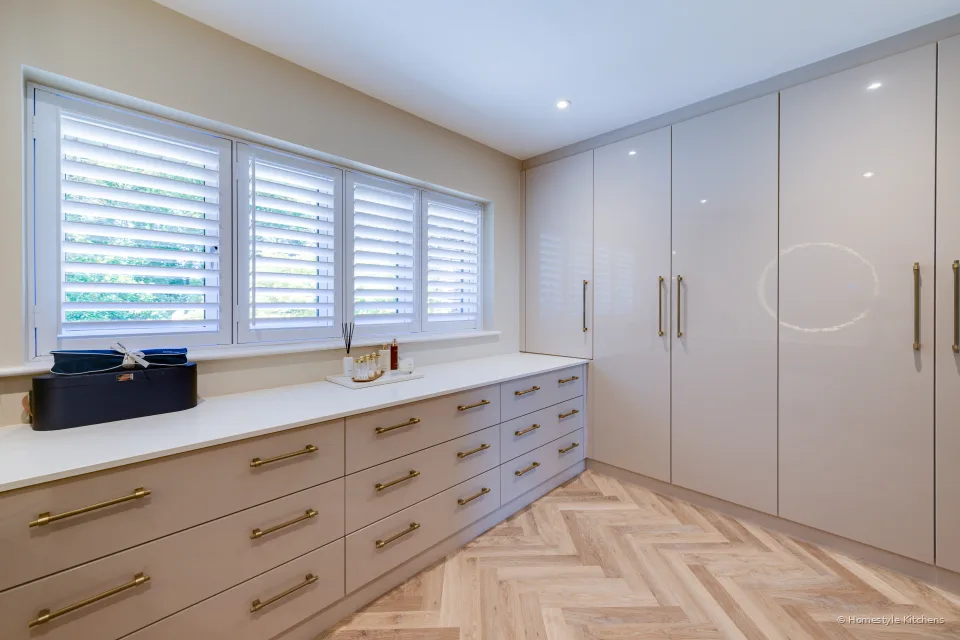 Long pale gloss dressing run under shuttered windows, herringbone oak.