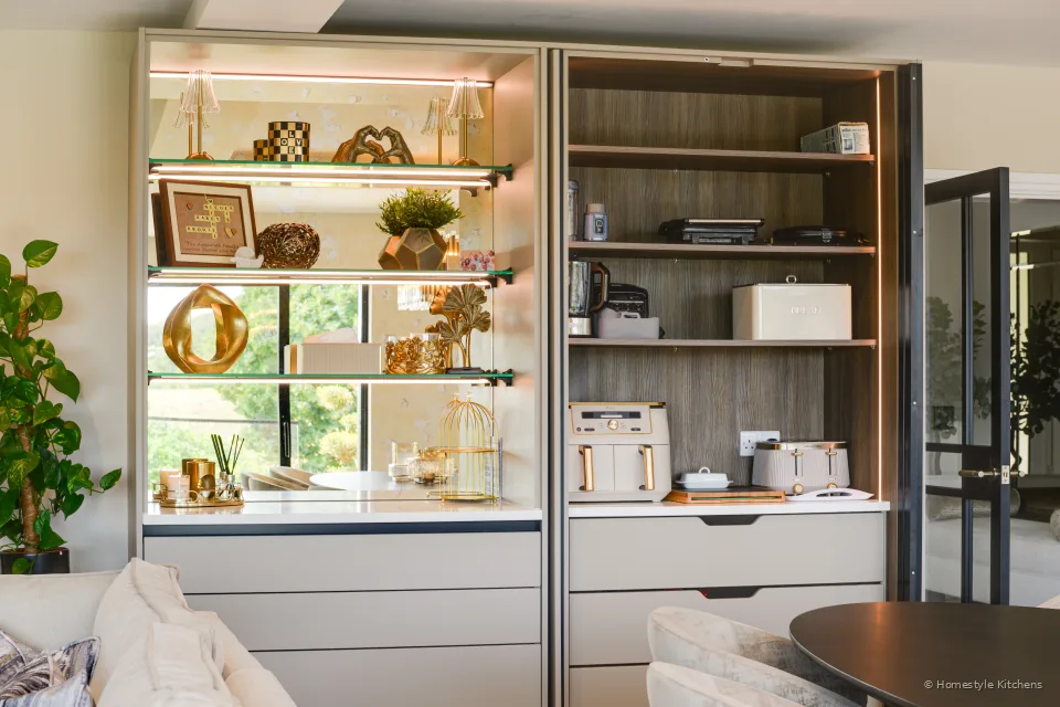 Lit bronze-framed glazed display shelving in the kitchen.