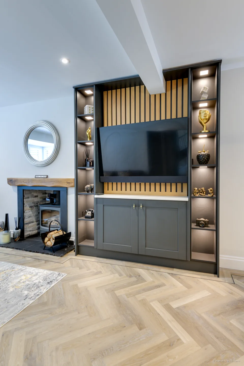 Grey media units with bronze-framed lit display shelving.