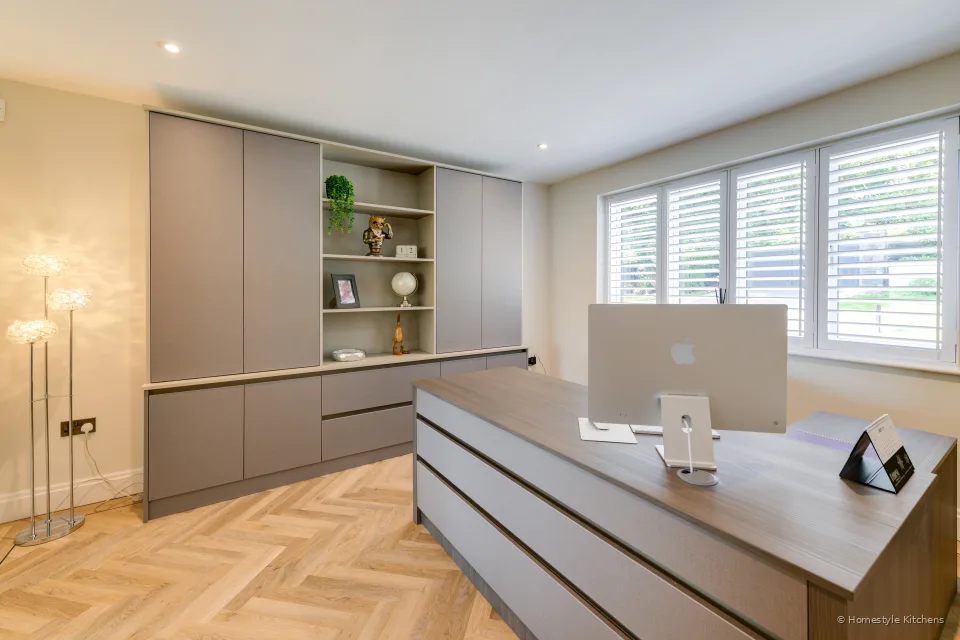 Taupe handleless office with open shelving and a dark timber desk.